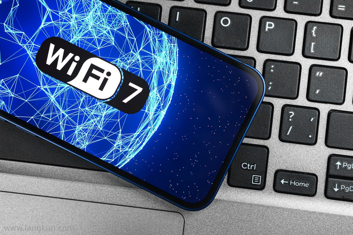 智能手机放在键盘上,显示着Wi-Fi 7的标志。